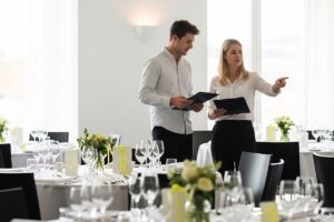 Event planners discussing setup and arrangements in a decorated banquet hall before an event