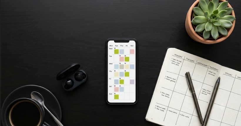 Flat lay of a phone showing a social media content calendar for small business scheduling tools